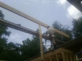 Carpenter setting a ridge beam over a new addition frame — Ice Dam Removal by Roofing Brothers in North Fork