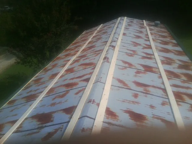 Rusted metal roof panels with new wood purlins before replacement — Storm Damage Roof Repair in North Fork by Roofing Brothers