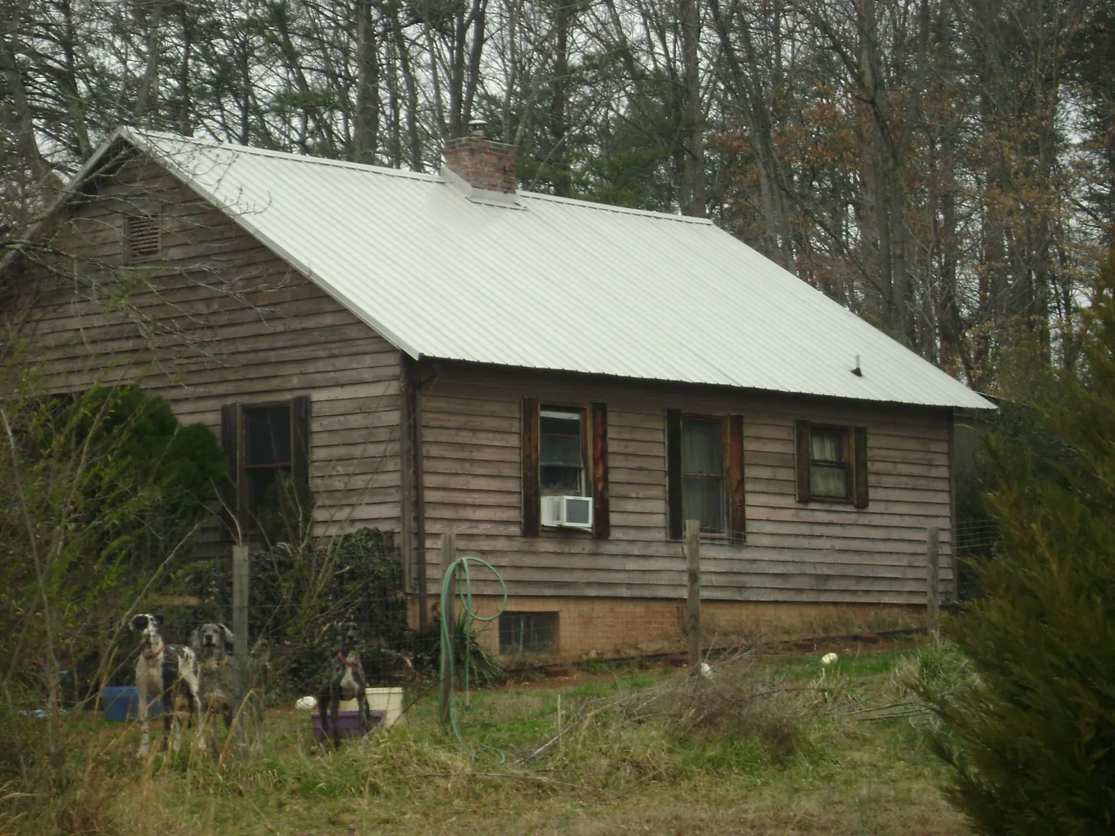 White metal roof on an old wood sided farmhouse, from a Metal Roof Installation job in North Fork